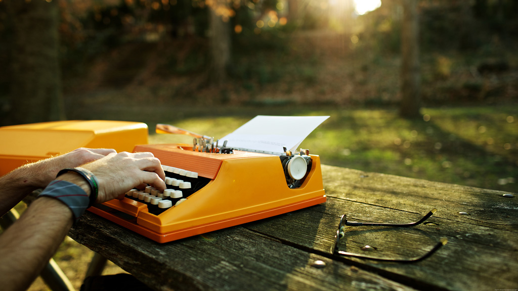 Hands on the orange typewriter in a park